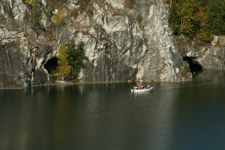 По водной глади плывет лодка с людьми
